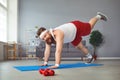 Funny fat man doing yoga exercises in the room.