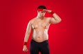 A funny fat man isolated on red background. Obesity and eating disorder. Concept for dietetics and fitness advertising