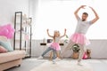 funny father and daughter in pink tutu skirts dancing Royalty Free Stock Photo