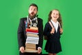 Funny father or teacher with school girl daughter hold big stack school textbook notebook books, isolated on green. Royalty Free Stock Photo