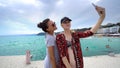 Funny female friends on vacation taking selfies on the beach with a smart phone Royalty Free Stock Photo