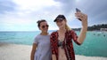 Funny female friends on vacation taking selfies on the pier with a smart phone Royalty Free Stock Photo
