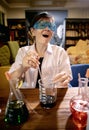 Funny female scientist in chemical laboratory