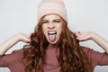 funny fenale wearing pink hat showing her tongue