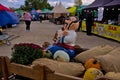 Funny figure of a colorful character, pumpkins and autumn flowers at an outdoor fair. Harvest festival.