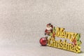 Funny figurine of Santa Claus on a glitter silver snow background with the golden words Merry Christmas and a Christmas Tree Royalty Free Stock Photo