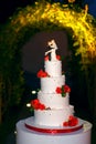Funny figurines suite at a luxury wedding white cake decorated with fresh flowers Royalty Free Stock Photo