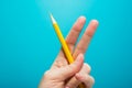 Funny fingers drawing holding yellow pencil against blue background. Conceptual motivation picture
