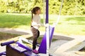 A funny five-year-old girl is doing street fitness on a simulator. A little beautiful girl does exercises on a street sports Royalty Free Stock Photo