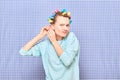 Funny focused young woman is putting her hair into colorful curlers Royalty Free Stock Photo