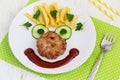 Funny food face with a chop, French fries and cucumber Royalty Free Stock Photo