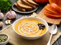 Funny food for Halloween. Pumpkin puree soup, spider web, dark old wooden table, side view. Royalty Free Stock Photo