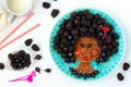 Funny food idea for children edible girl, face from pancake, gooseberry and blackberry, food art