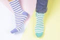 Funny foots in mismatched stripped socks on colorful background. Odd Socks day, Anti-Bullying Week, Down syndrome