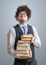 Funny freak nerd professor holds many books in hands Royalty Free Stock Photo