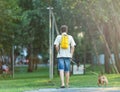 Funny french puppy bulldog and teenager playing games outside. Adorable orange bulldog in blue harness in the playground on sand. Royalty Free Stock Photo