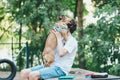 Funny french puppy bulldog and teenager playing games outside. Adorable orange bulldog in blue harness in the playground on sand. Royalty Free Stock Photo