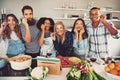 Funny friends making fake asparagus moustache.