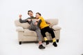 Funny friends on the white couch. Two guys on the couch laughing. Gay couple in love. Two young handsome boys sitting on