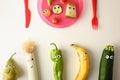 Funny fruit and vegetables served with children`s cutlery on table Royalty Free Stock Photo