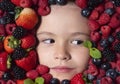 Funny fruits. Assorted mix of strawberry, blueberry, raspberry, blackberry background. Berries closeup near kids face Royalty Free Stock Photo