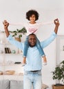 Funny games with granddad. Senior African American man carrying his granddaughter on shoulders at home Royalty Free Stock Photo