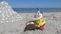 Funny garden dwarf with wheelbarrow on the beach