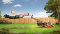 Funny gardener being pulled through the garden by a lawn mower