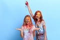 Funny ginger girl throwing colored powder on her friend`s head Royalty Free Stock Photo