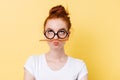 Funny ginger woman in eyeglasses playing with pencil Royalty Free Stock Photo