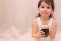 funny girl in ballerina tutu with a glass of hot drink in her hands