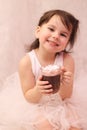 funny girl in ballerina tutu with a glass of hot drink in her hands