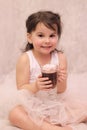 funny girl in ballerina tutu with a glass of hot drink in her hands