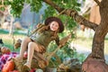 Funny girl child kid in halloween green costume playing outdoor with spooky jack pumpkins with scary faces sitting on swing west Royalty Free Stock Photo