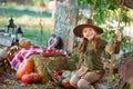 Funny girl child kid in halloween green costume playing outdoor with spooky jack pumpkins with scary faces sitting on swing west Royalty Free Stock Photo