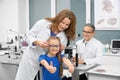 Funny girl choosing new glasses in optical shop