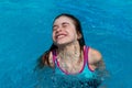 Funny girl dives and comes up to the surface of the swimming poo Royalty Free Stock Photo