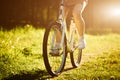 Funny girl driving outdoor. Focus on bicycle. Sunny summer lifestyle concept. Woman in dress and hat in Field with Royalty Free Stock Photo