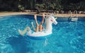 Funny girl dropped fell from inflatable ring unicorn. Kid child enjoying having fun in a swimming pool. Summer outdoor water