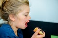 Funny girl eating bread roll with marmelade Royalty Free Stock Photo