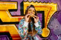 Funny girl eating yummy hamburger on the background of graffiti