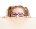 Funny girl in eyeglasses hiding behind table Royalty Free Stock Photo