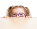 Funny girl in eyeglasses hiding behind table