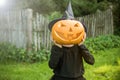 Funny girl with halloween pumpki in garden