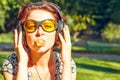 Funny girl with headphones listen to music and inflates a chewing gum Royalty Free Stock Photo