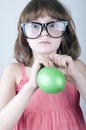 Funny girl with herd sunglasses blowing a balloon Royalty Free Stock Photo