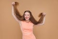Funny girl holding her long brown hairs and looking at camera wi Royalty Free Stock Photo