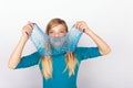 Funny girl holding a transpareng blue glitter slime in front of her face Royalty Free Stock Photo