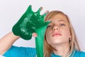 Funny girl playing with green slime looks like gunk on her hand Royalty Free Stock Photo