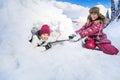 Funny girl pull on her friend from the snow igloo Royalty Free Stock Photo